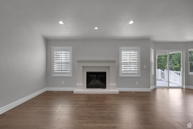 5575 S 1350 E, South Ogden, UT 84403 - unfurnished living room with a glass covered fireplace, recessed lighting, and wood finished floors