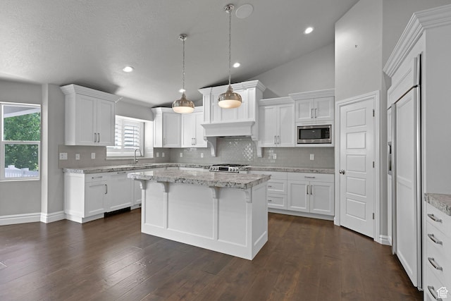 5575 S 1350 E, South Ogden, UT 84403 - kitchen featuring stainless steel microwave, backsplash, white cabinets, a kitchen island, and stove