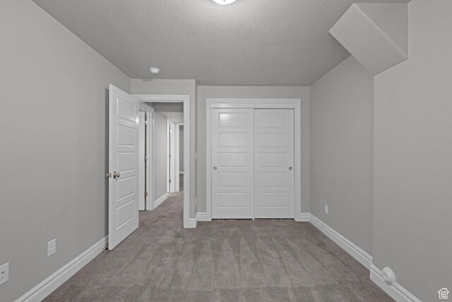 5575 S 1350 E, South Ogden, UT 84403 - unfurnished bedroom with carpet floors, a textured ceiling, and a closet