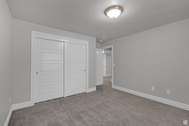 5575 S 1350 E, South Ogden, UT 84403 - unfurnished bedroom featuring carpet, a closet, and a textured ceiling