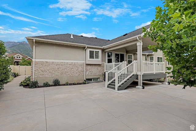 5575 S 1350 E, South Ogden, UT 84403 - back of property featuring a patio, stucco siding, a deck with mountain view, and a shingled roof