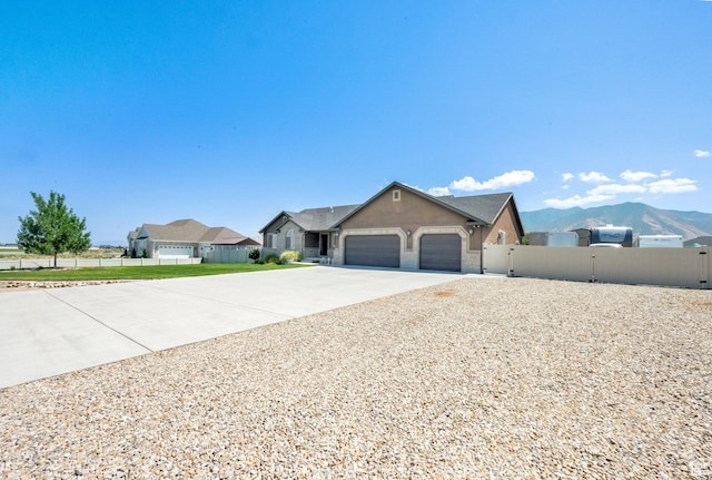 4390 N Diamond Ln, Erda, UT 84074 - ranch-style house with a garage, driveway, stucco siding, a gate, and a mountain view