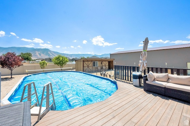 4390 N Diamond Ln, Erda, UT 84074 - view of swimming pool featuring a fenced backyard, a storage unit, a deck with mountain view, and an outdoor living space