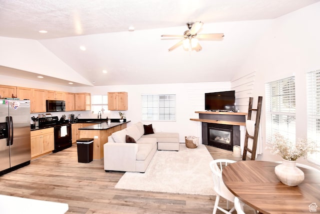 1568 Dawson Ln, Tooele, UT 84074 - living area featuring a glass covered fireplace, light wood-style floors, a ceiling fan, recessed lighting, and high vaulted ceiling