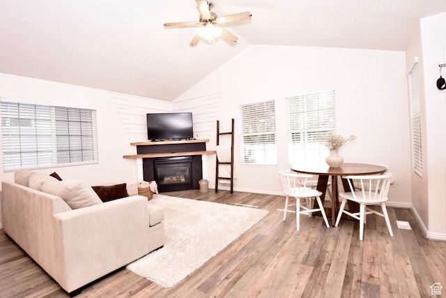 1568 Dawson Ln, Tooele, UT 84074 - living room with a glass covered fireplace, a ceiling fan, wood finished floors, and lofted ceiling