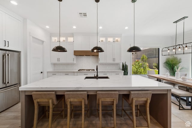 2950 E Naboo Ln, St George, UT 84790 - kitchen with high quality fridge, tasteful backsplash, glass insert cabinets, a breakfast bar, and recessed lighting