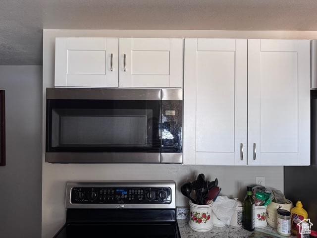 54 W 300 S, Orem, UT 84058 - kitchen view of stainless steel microwave, stove, and white cabinets