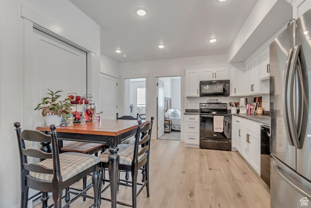 1058 W 570 N, Orem, UT 84057 - kitchen with black appliances, white cabinets, light wood-style flooring, dark countertops, and recessed lighting
