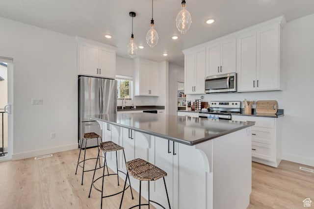 1058 W 570 N, Orem, UT 84057 - kitchen featuring stainless steel appliances, recessed lighting, a kitchen island, a breakfast bar area, and dark countertops