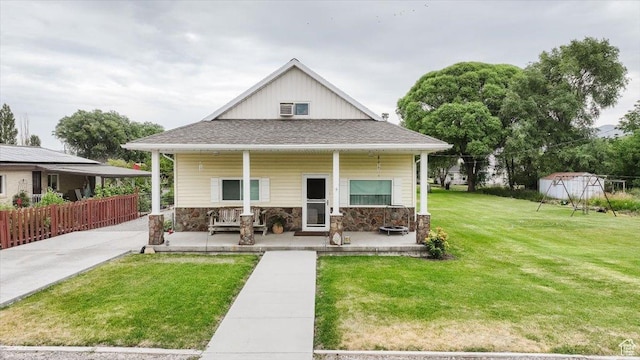 14360 N 6000 W, Garland, UT 84312 - view of front facade featuring a porch, a front lawn, and stone siding