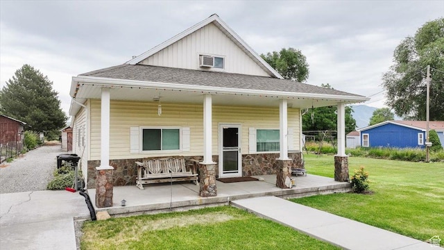 14360 N 6000 W, Garland, UT 84312 - view of front of home with a front lawn, stone siding, board and batten siding, and covered porch