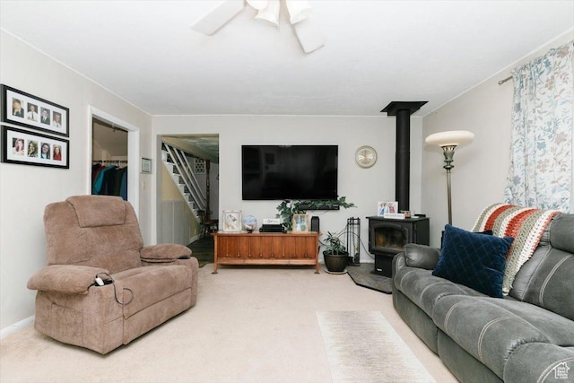 14360 N 6000 W, Garland, UT 84312 - carpeted living room featuring a wood stove, stairway, and ceiling fan