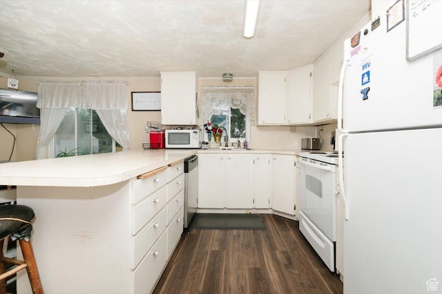 14360 N 6000 W, Garland, UT 84312 - kitchen with white appliances, a peninsula, light countertops, and white cabinets