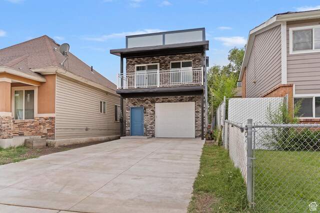 2835 Lincoln Ave, Ogden, UT 84401 - view of front of home featuring a balcony, concrete driveway, a garage, and brick siding