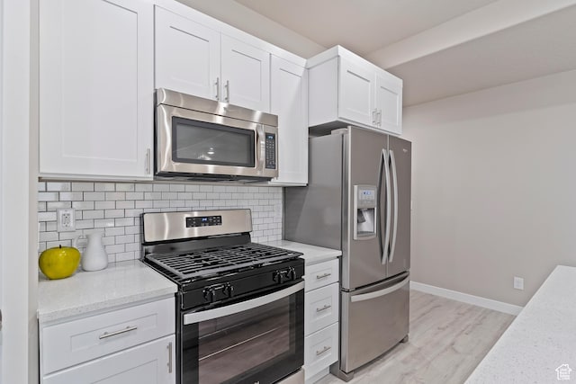 2835 Lincoln Ave, Ogden, UT 84401 - kitchen featuring appliances with stainless steel finishes, light wood-style flooring, tasteful backsplash, and white cabinetry