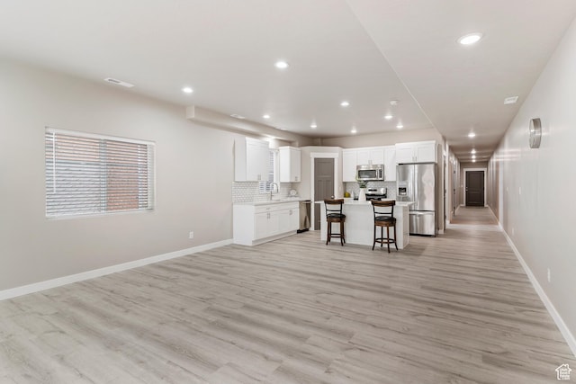 2835 Lincoln Ave, Ogden, UT 84401 - kitchen with stainless steel appliances, a breakfast bar area, recessed lighting, backsplash, and white cabinetry