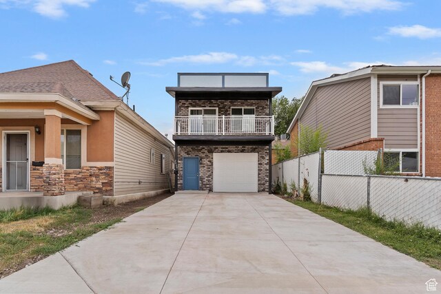 2835 Lincoln Ave, Ogden, UT 84401 - view of front of house with driveway, a balcony, an attached garage, and stone siding