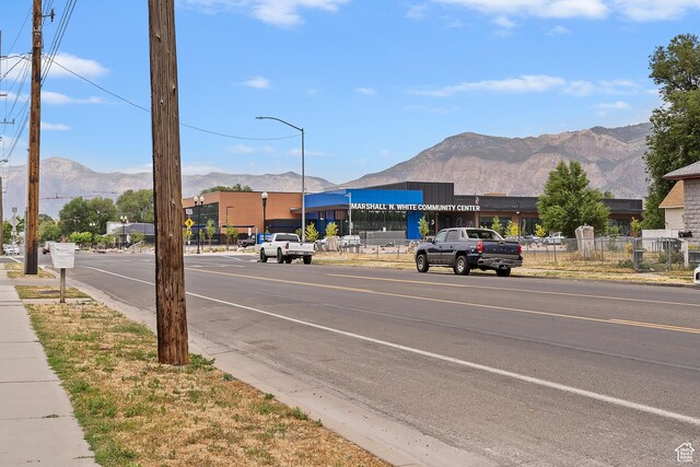 2835 Lincoln Ave, Ogden, UT 84401 - view of asphalt street featuring street lights, a mountain view, sidewalks, and curbs