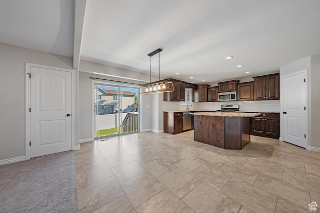 488 N 1375 E, Layton, UT 84040 - kitchen with appliances with stainless steel finishes, dark brown cabinetry, backsplash, a center island, and hanging light fixtures