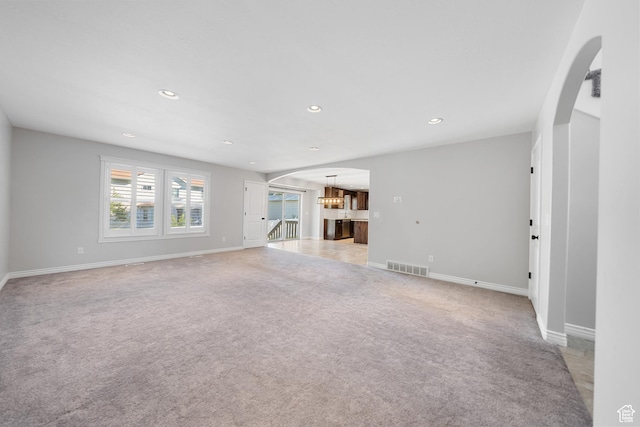 488 N 1375 E, Layton, UT 84040 - unfurnished living room featuring light colored carpet, a chandelier, recessed lighting, and arched walkways