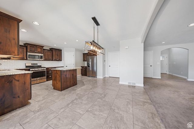 488 N 1375 E, Layton, UT 84040 - kitchen with stainless steel appliances, open floor plan, arched walkways, a kitchen island, and dark brown cabinetry