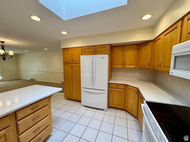 1341 E 5200 S, South Ogden, UT 84403 - kitchen with white appliances, brown cabinetry, light tile patterned flooring, a chandelier, and a skylight