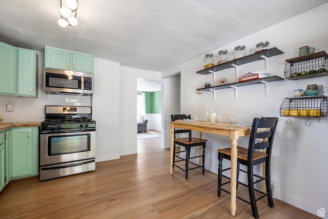 190 N 200 E, Pleasant Grove, UT 84062 - kitchen with stainless steel appliances, light wood-type flooring, tasteful backsplash, and green cabinets