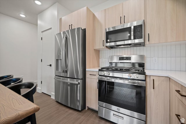 3840 N 4975 E Unit A104, Eden, UT 84310 - kitchen featuring stainless steel appliances, light brown cabinets, dark wood-style flooring, light countertops, and backsplash