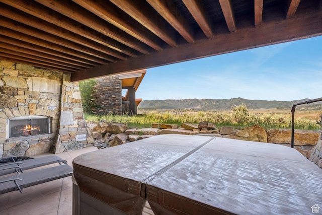 7881 N W Hills Trl, Park City, UT 84098 - view of patio featuring an outdoor stone fireplace, a mountain view, and a covered hot tub