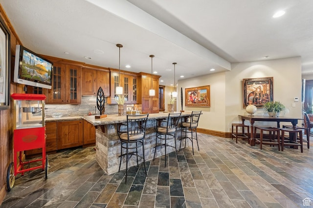 7881 N W Hills Trl, Park City, UT 84098 - kitchen with brown cabinetry, recessed lighting, a breakfast bar, decorative backsplash, and hanging light fixtures