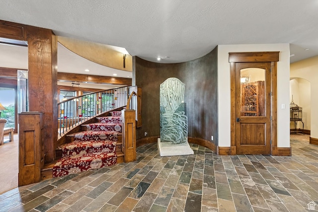 7881 N W Hills Trl, Park City, UT 84098 - entryway featuring arched walkways, recessed lighting, stairs, stone finish floors, and a textured ceiling