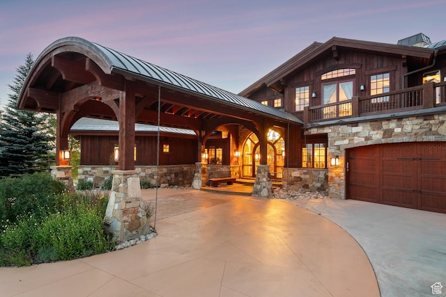 7881 N W Hills Trl, Park City, UT 84098 - view of front of home featuring a standing seam roof, stone siding, a metal roof, a balcony, and a garage