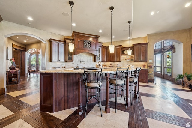 7881 N W Hills Trl, Park City, UT 84098 - kitchen featuring arched walkways, inlaid floor details, plenty of natural light, decorative backsplash, and recessed lighting