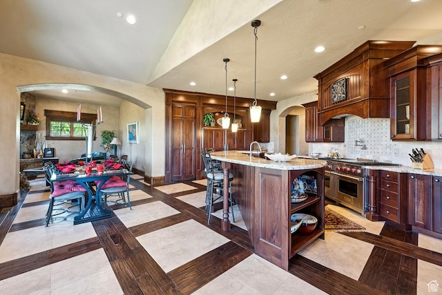 7881 N W Hills Trl, Park City, UT 84098 - kitchen with inlaid floor details, double oven range, arched walkways, recessed lighting, and light stone counters