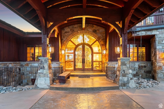 7881 N W Hills Trl, Park City, UT 84098 - exterior entry at dusk with stone siding, french doors, and covered porch