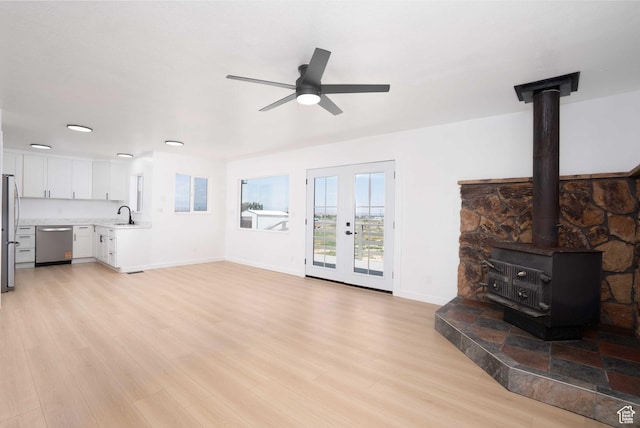 3189 S 4000 W, Roosevelt, UT 84066 - unfurnished living room with a ceiling fan, light wood finished floors, a wood stove, and recessed lighting