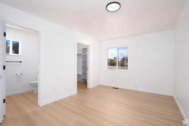 3189 S 4000 W, Roosevelt, UT 84066 - unfurnished bedroom with light wood-style flooring, multiple windows, a walk in closet, and a closet