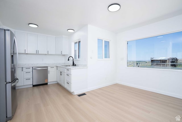 3189 S 4000 W, Roosevelt, UT 84066 - kitchen featuring appliances with stainless steel finishes, light wood-type flooring, white cabinetry, and open floor plan