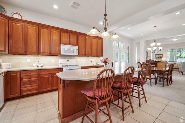 10693 S Vermillion Dr, South Jordan, UT 84009 - kitchen with white appliances, light countertops, light tile patterned floors, brown cabinets, and decorative light fixtures