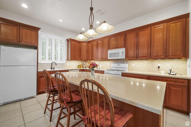 10693 S Vermillion Dr, South Jordan, UT 84009 - kitchen with white appliances, a kitchen island, light countertops, tasteful backsplash, and a kitchen bar