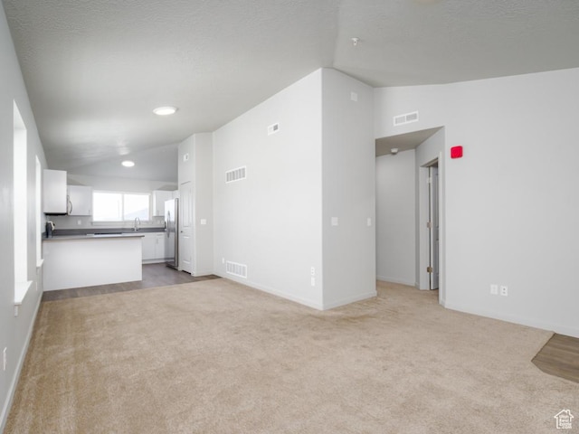 1141 E 1320 S Unit A401, Provo, UT 84606 - unfurnished living room with light colored carpet, recessed lighting, a textured ceiling, and vaulted ceiling