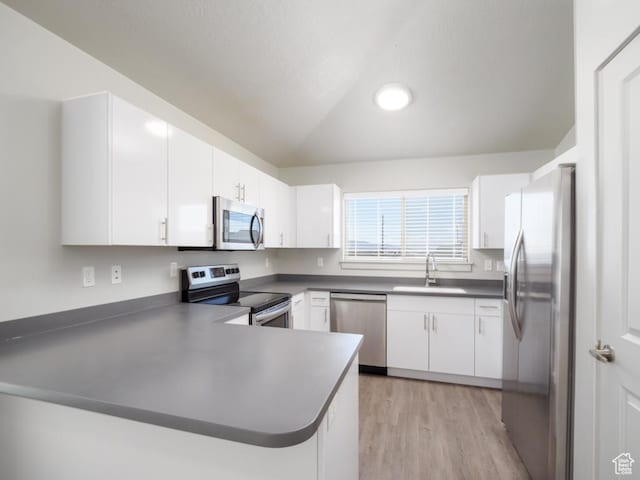 1141 E 1320 S Unit A401, Provo, UT 84606 - kitchen featuring appliances with stainless steel finishes, a peninsula, light wood-style flooring, dark countertops, and white cabinets