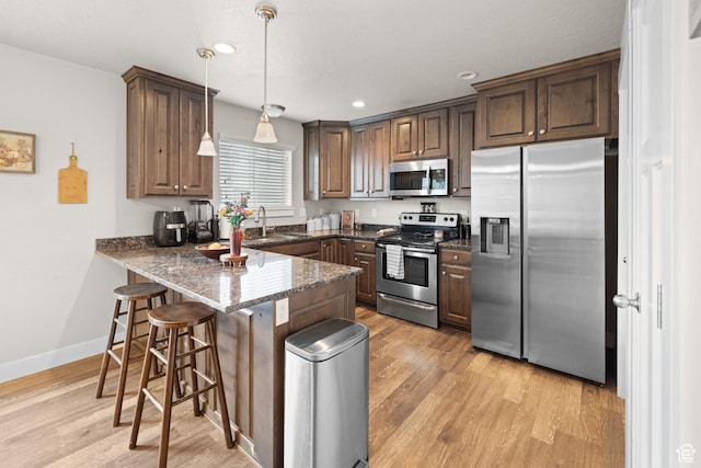 2501 W 1100 N, Provo, UT 84604 - kitchen with appliances with stainless steel finishes, a peninsula, light wood-type flooring, a kitchen breakfast bar, and recessed lighting