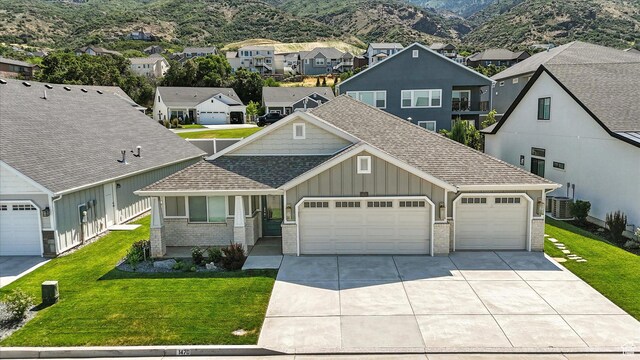 1470 N Cobblewood Ct, Kaysville, UT 84037 - view of front of house with board and batten siding, a shingled roof, brick siding, and concrete driveway