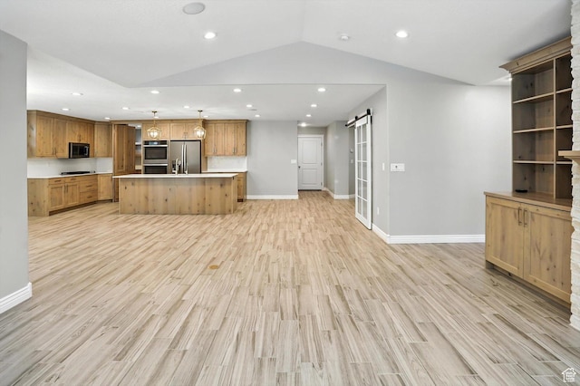 1470 N Cobblewood Ct, Kaysville, UT 84037 - kitchen featuring appliances with stainless steel finishes, open floor plan, a barn door, light wood-style flooring, and light countertops