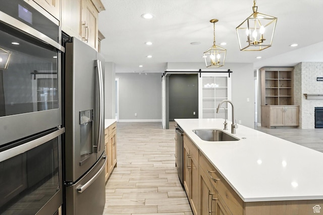 1470 N Cobblewood Ct, Kaysville, UT 84037 - kitchen with stainless steel appliances, light wood-style flooring, a chandelier, open floor plan, and a barn door