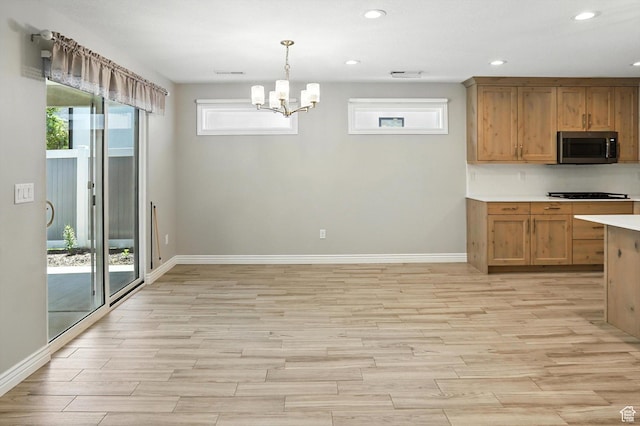 1470 N Cobblewood Ct, Kaysville, UT 84037 - kitchen featuring stainless steel microwave, light wood-style floors, light countertops, a chandelier, and recessed lighting