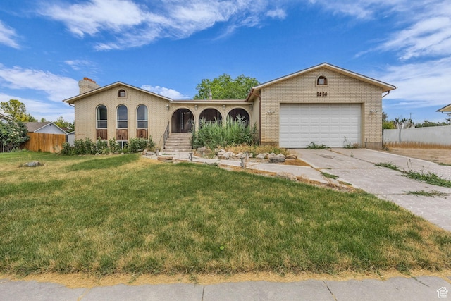 5350 S 3450 W, Roy, UT 84067 - view of front of house featuring concrete driveway, brick siding, and a chimney