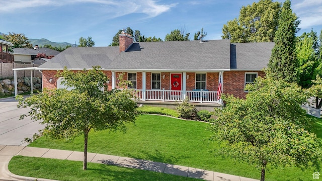 1138 Briggs Dr, Bountiful, UT 84010 - view of front facade with brick siding, a chimney, a front lawn, and roof with shingles