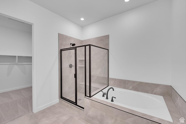 1086 S 3170 E Unit 217, Spanish Fork, UT 84660 - bathroom with a bath, a stall shower, a walk in closet, recessed lighting, and tile patterned floors